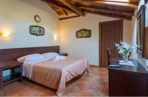 a bedroom with a bed and a desk and a table with flowers at Villa Casina dell'Etna in Ragalna