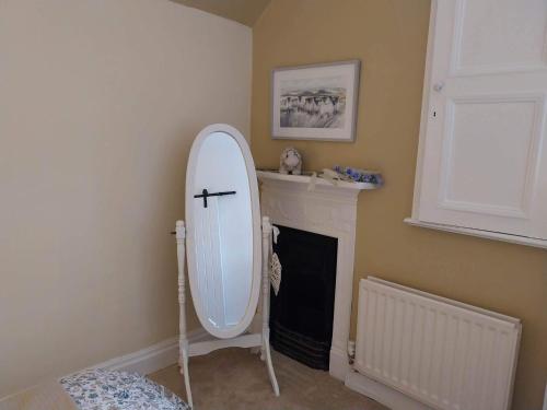 a white mirror in a room with a fireplace at JESMOND House B&B room 4 in Hull