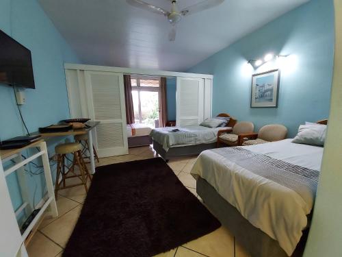 Habitación con 2 camas, cocina y sala de estar. en Ocean Breeze, en Warner Beach