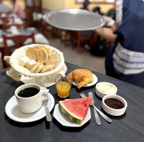 a table topped with plates of food and cups of coffee at Hotel Los Ángeles in San Clemente del Tuyú