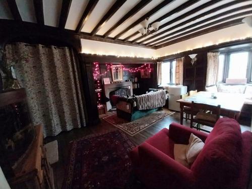 a living room with a red couch and a table at JESMOND House B&B room 1 in Hull