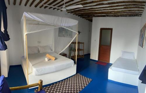 a bedroom with two beds and a canopy bed at Babalao Rooftop Hotel in Paje
