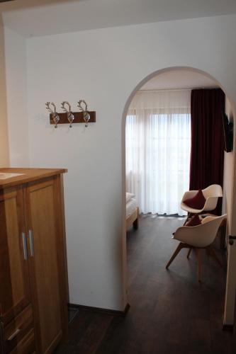 a living room with a chair and a table at Hotel Garni Schlossblick in Hohenschwangau