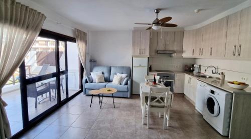 cocina y sala de estar con sofá y mesa en Apartamento Brisas del Mar, en San Miguel de Abona