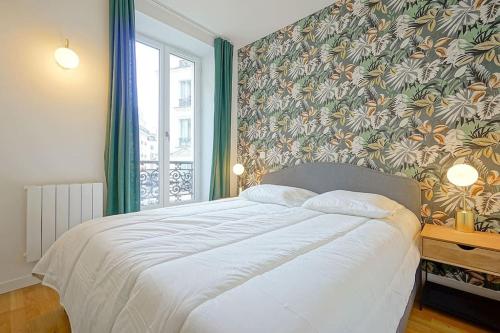 - une chambre avec un grand lit et du papier peint floral dans l'établissement Elegant appartement dans le Marais - Paris 3, à Paris