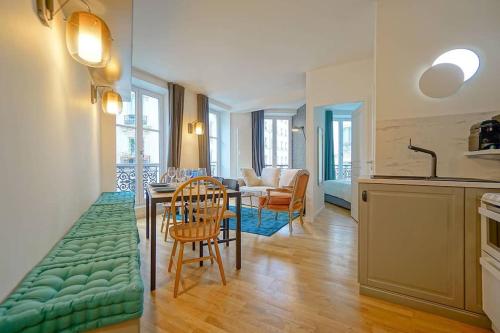 une cuisine et un salon avec une table et des chaises dans l'établissement Elegant appartement dans le Marais - Paris 3, à Paris