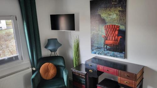 a living room with a chair and a desk at EGE sleep & stay at Kassel - Fasanenweg in Kassel