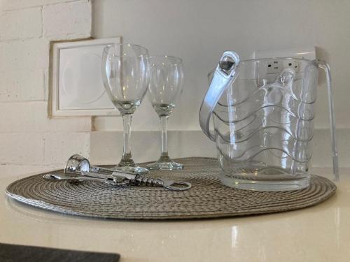 a table with two glasses and a vase and keys at Apartamento de lujo Manizales in Manizales