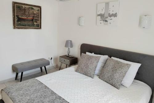 een slaapkamer met een bed met witte lakens en kussens bij Villa Aurelie in Cap d'Agde