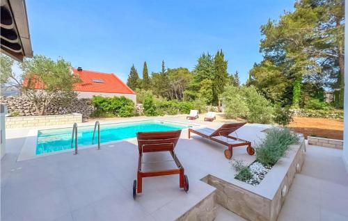 a patio with two chairs and a swimming pool at Stunning Apartment In Zrnovo With Wifi in Žrnovo