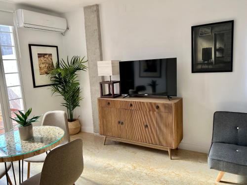 una sala de estar con TV de pantalla plana en un armario de madera en El patio de Cruz Conde en Córdoba