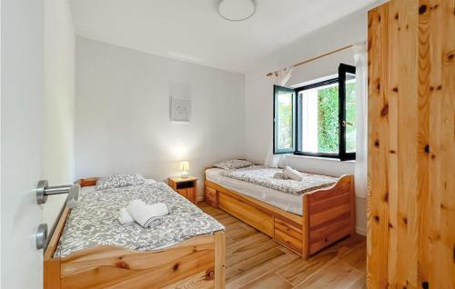 a bedroom with two beds and a window at Beautiful Apartment In Zrnovo With Outdoor Swimming Pool, 3 Bedrooms And Wifi in Žrnovo