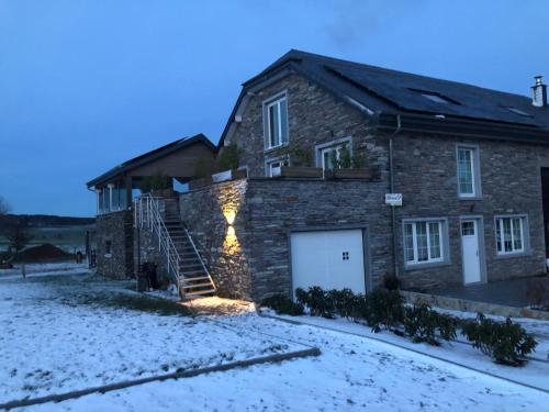 a brick house with a garage in the snow at PEGASUS I - 2 chambres de luxe, cuisine, salon, 2 terrasses et sauna in Vielsalm