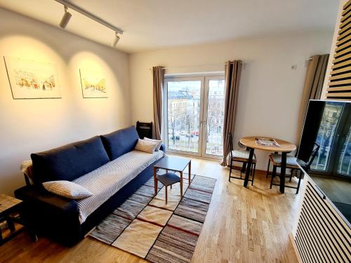 a living room with a blue couch and a table at Open View City Apartment in Vienna