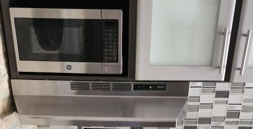 a microwave above a stove in a kitchen at Palm's Luxury Suite with Private Jacuzzi in Aguada