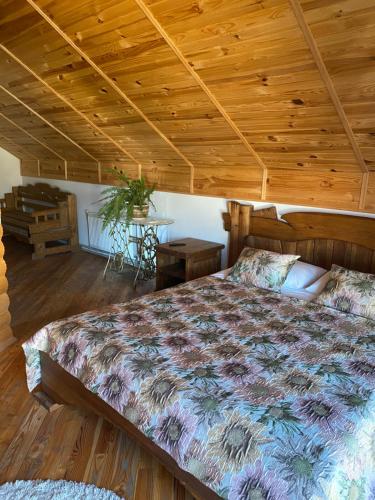 a bedroom with a bed with a wooden ceiling at VIP House in Mykulychyn