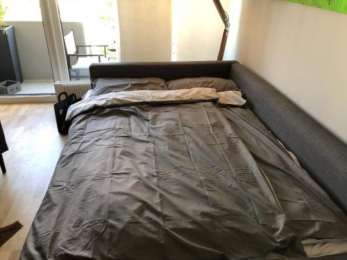 a bed with a gray comforter in a bedroom at 21st Appartement in Düsseldorf