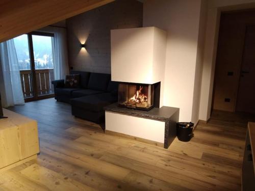 a living room with a fireplace in the middle at Appartamento l’ Aier - Arabba - Dolomiti in Livinallongo del Col di Lana