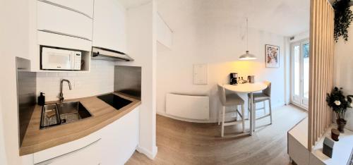 une cuisine et un salon avec un évier et une table dans l'établissement Sur un nuage - Terrasse - Gare - Hypercentre, à Toulouse