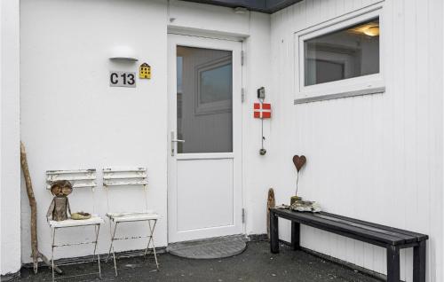 a teddy bear sitting on two chairs next to a door at Stunning Home In Tranekær in Tranekær