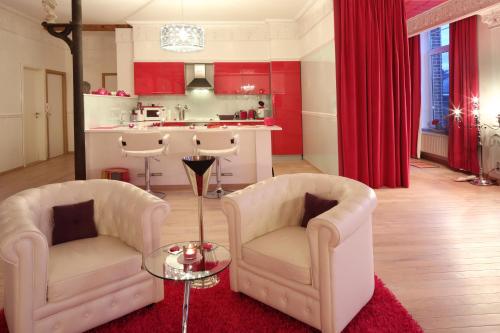 a living room with two chairs and a kitchen at Studio Le Baiser d'Angeli in Ensival