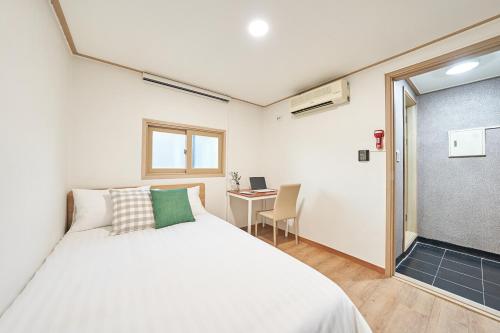 a bedroom with a white bed and a desk at K'STAY Sinchon in Seoul