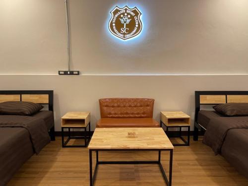 a room with two beds and a clock on the wall at Yaowarate Sport Club and Resort ไร่เยาวเรศ in Ban Mae Ho Phra