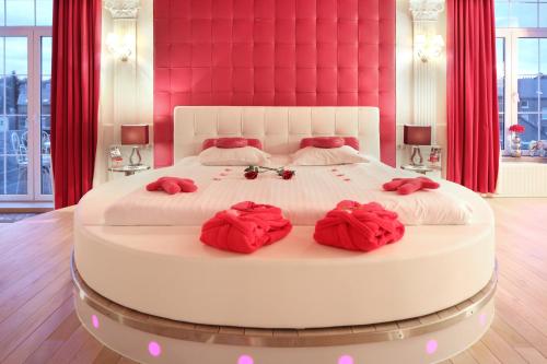 a bedroom with a large white bed with red pillows at Studio Le Baiser d'Angeli in Ensival