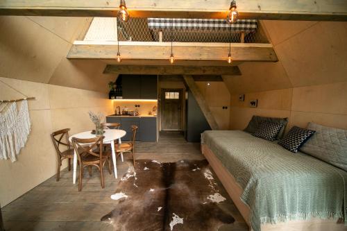 um quarto com uma cama, uma mesa e cadeiras em Hygge Chalet 