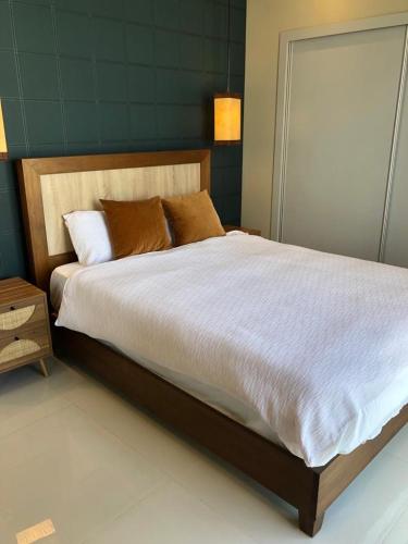 a bedroom with a large bed with white sheets at Piantini’s Skylight in Santo Domingo