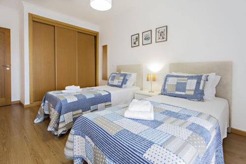 Habitación con 2 camas y sábanas azules y blancas. en Lavender Apartment en Santa Luzia