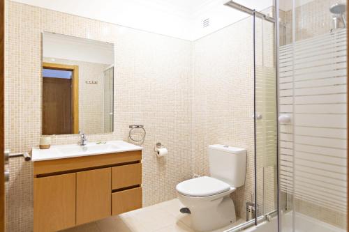 y baño con aseo, lavabo y ducha. en Lavender Apartment en Santa Luzia