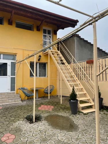 a yellow house with a staircase in front of it at Apartament la casa in Timişoara
