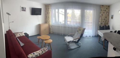 a living room with a red couch and a table at Residenz Majesta in Leukerbad