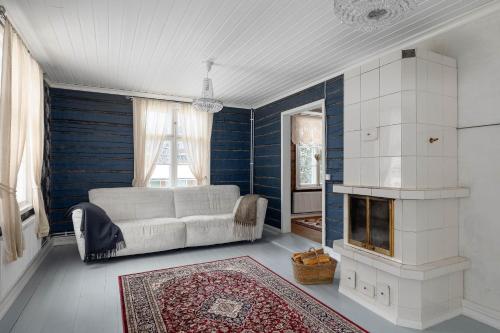 a living room with a couch and a fireplace at Maalaishuvila Wanha Virkailija Iittala in Hämeenlinna