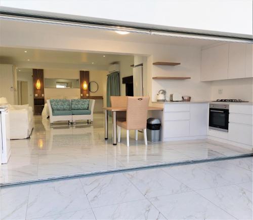 a kitchen and living room with a table and chairs at Soli Deo Gloria, Pearl Studio in Paternoster