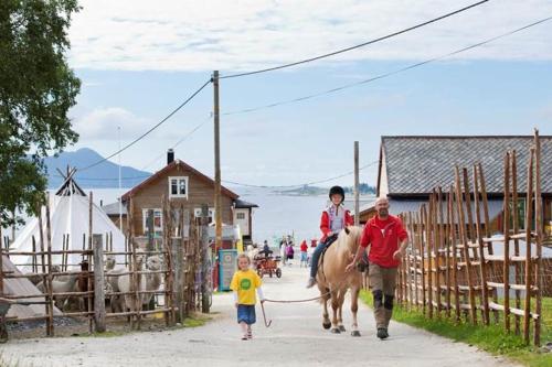 a man and child riding a horse with a child on it at Nyoppusset leilighet. Dusj med steambad. in Åheim