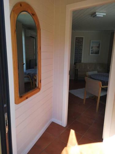 a hallway with a mirror and a room with a table at Nyoppusset leilighet. Dusj med steambad. in Åheim
