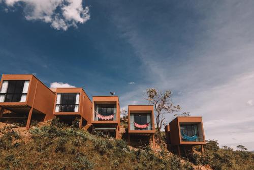 a group of three houses on top of a hill at Vila Toá in Alto Paraíso de Goiás