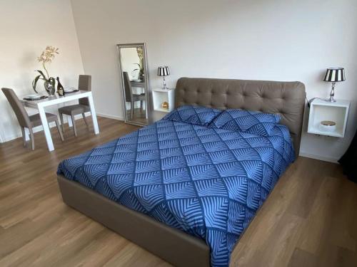 a bed with a blue comforter in a room at Alloggio con favolosa vista lago Lugano Paradiso in Paradiso