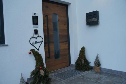 a door with christmas trees in front of it at Apart Egger in Schwendau