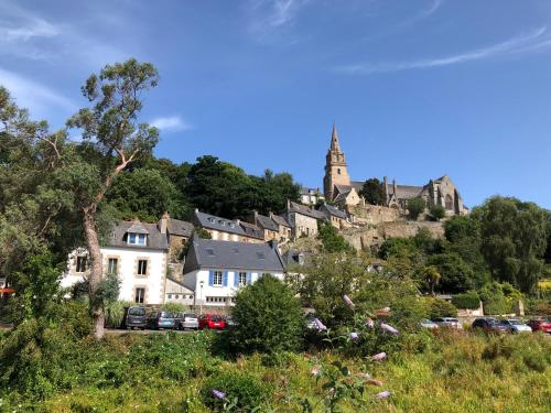 a village on a hill with a church in the background at Au cœur du quartier historique in Lannion