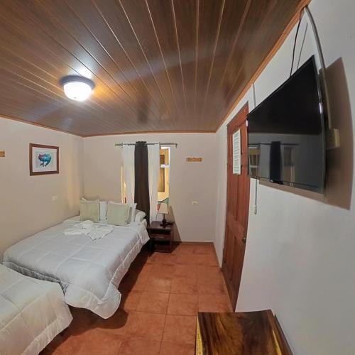 a bedroom with two beds and a flat screen tv at Casa Jungle Monteverde B&B in Monteverde Costa Rica