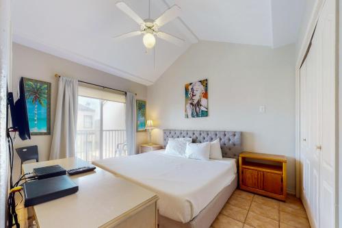 a bedroom with a bed and a desk with a laptop at Dolphin #22 in South Padre Island