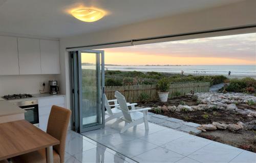 a kitchen with a view of the beach at Soli Deo Gloria, Pearl Studio in Paternoster