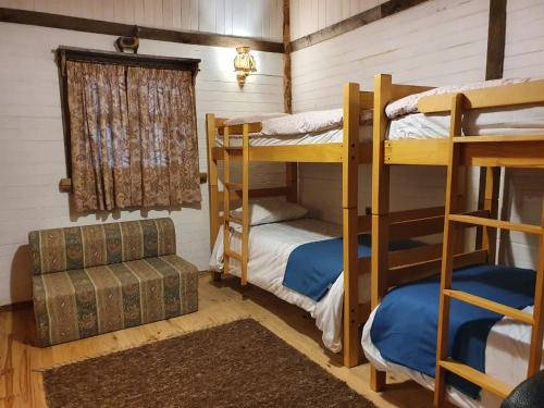 a room with two bunk beds and a couch at Huincaterra in Villarrica