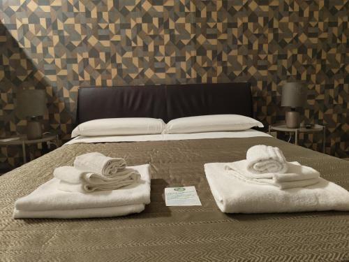 カターニアにあるホテル トリエステのベッドの上にタオル2枚、枕2つ