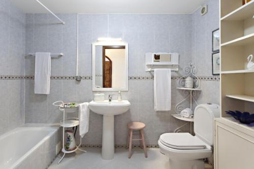 ein Badezimmer mit einem Waschbecken, einem WC und einer Badewanne in der Unterkunft Apartamento Maresia in Faro