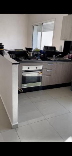 a kitchen with a stove and a counter top at Appartement avec piscine in Pont Blondin