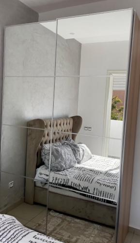 a mirror reflection of a bed in a bedroom at Appartement avec piscine in Pont Blondin
